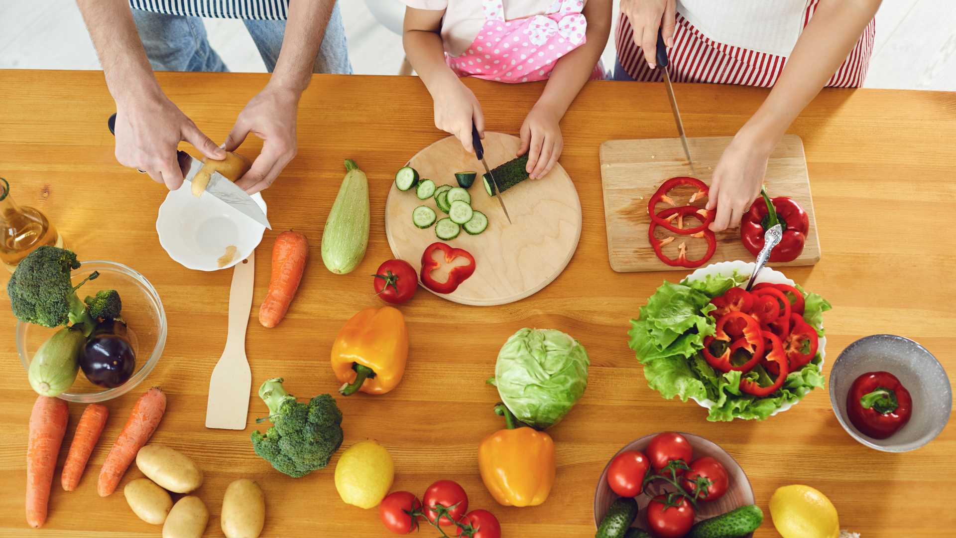 Famille qui cuisine ensemble des légumes