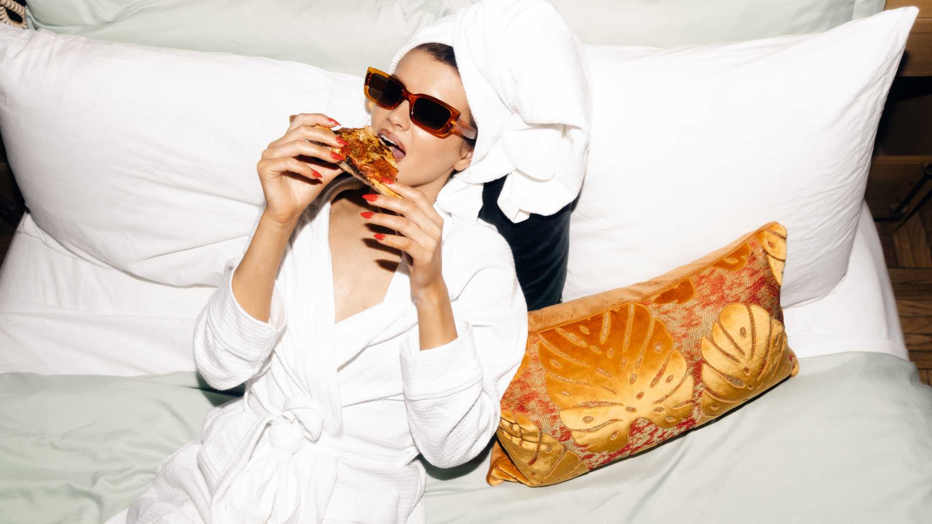femme qui mange une pizza dans son lit