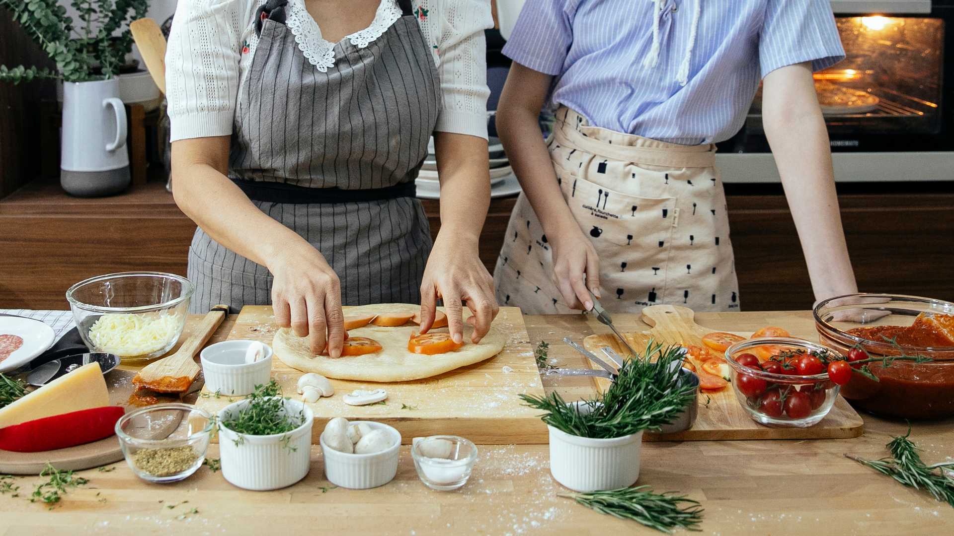 Deux femmes avec un tablier entrain de cuisiner